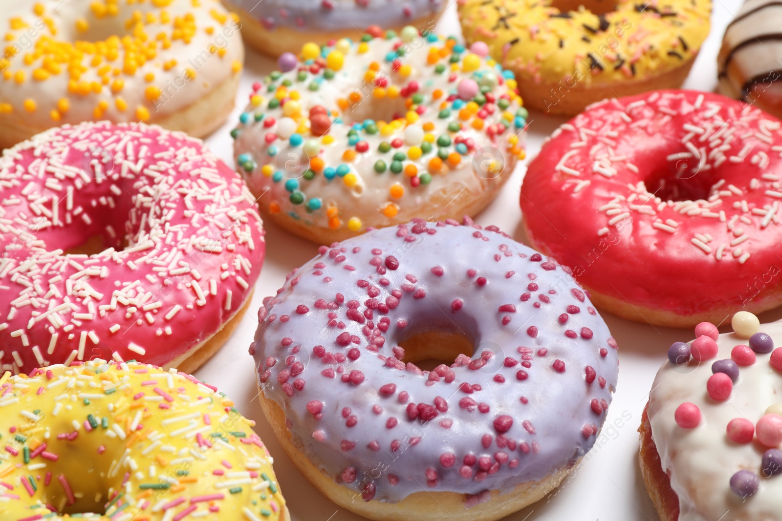 Photo of Delicious glazed donuts on white background, closeup