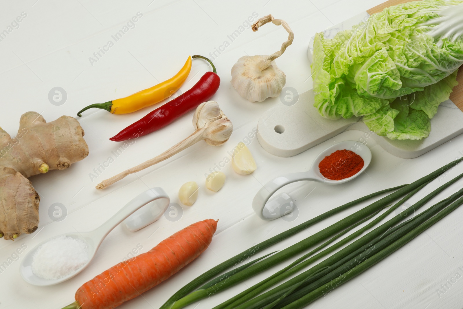 Photo of Composition with fresh Chinese cabbages and ingredients on white wooden table