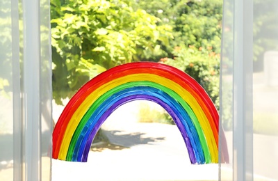 Painting of rainbow on window indoors. Stay at home concept