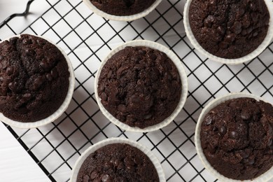 Tasty chocolate muffins on white wooden table, top view