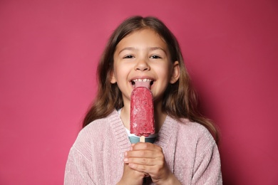 Photo of Adorable little girl with delicious ice cream against color background