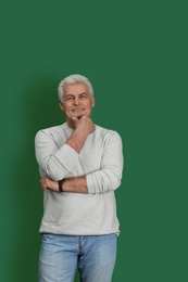 Photo of Portrait of handsome mature man on color background