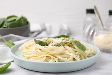 Photo of Tasty pasta with spinach, cheese and sauce on white marble table, closeup