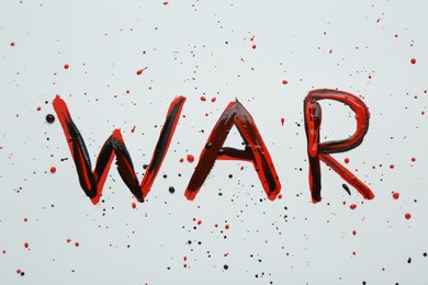 Photo of Word War written with black and red paint on white background, top view