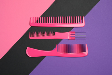 Photo of Set of pink combs on color background, flat lay