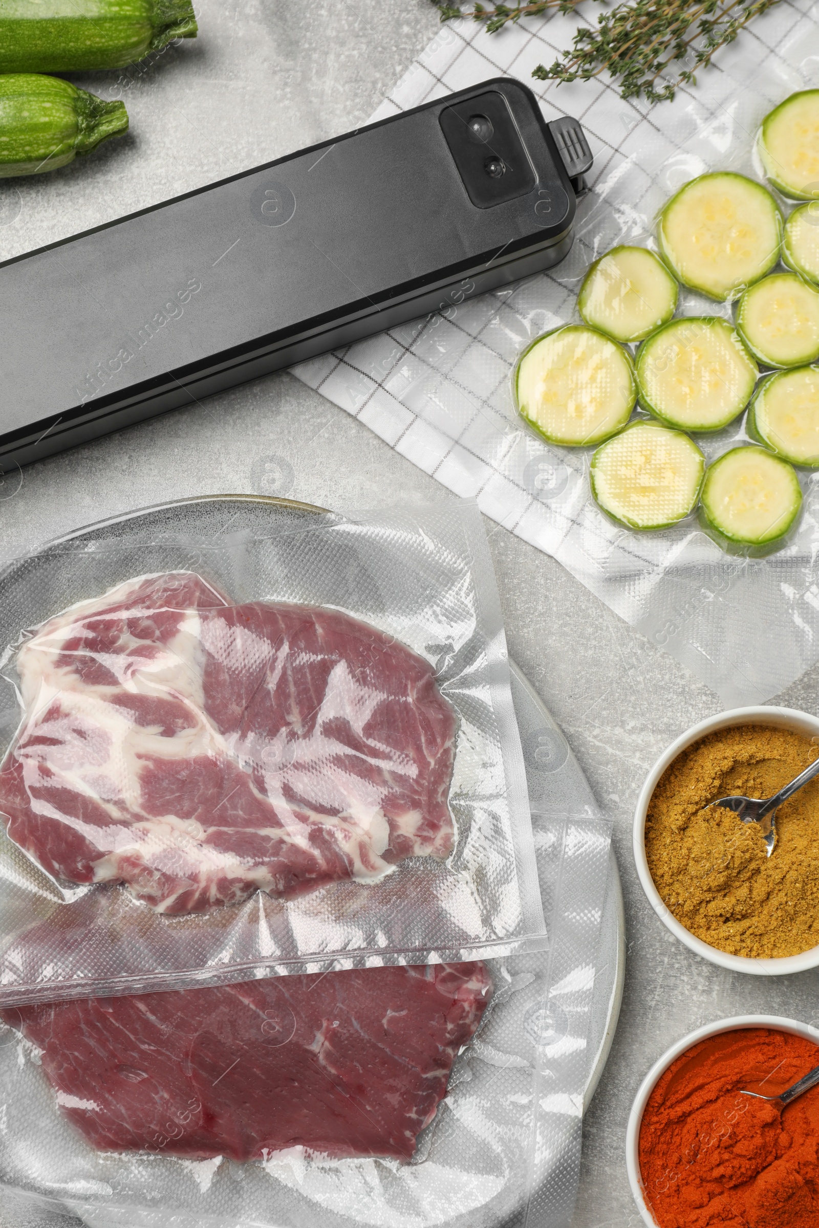 Photo of Flat lay composition of different food, spices and sealer for vacuum packing on table