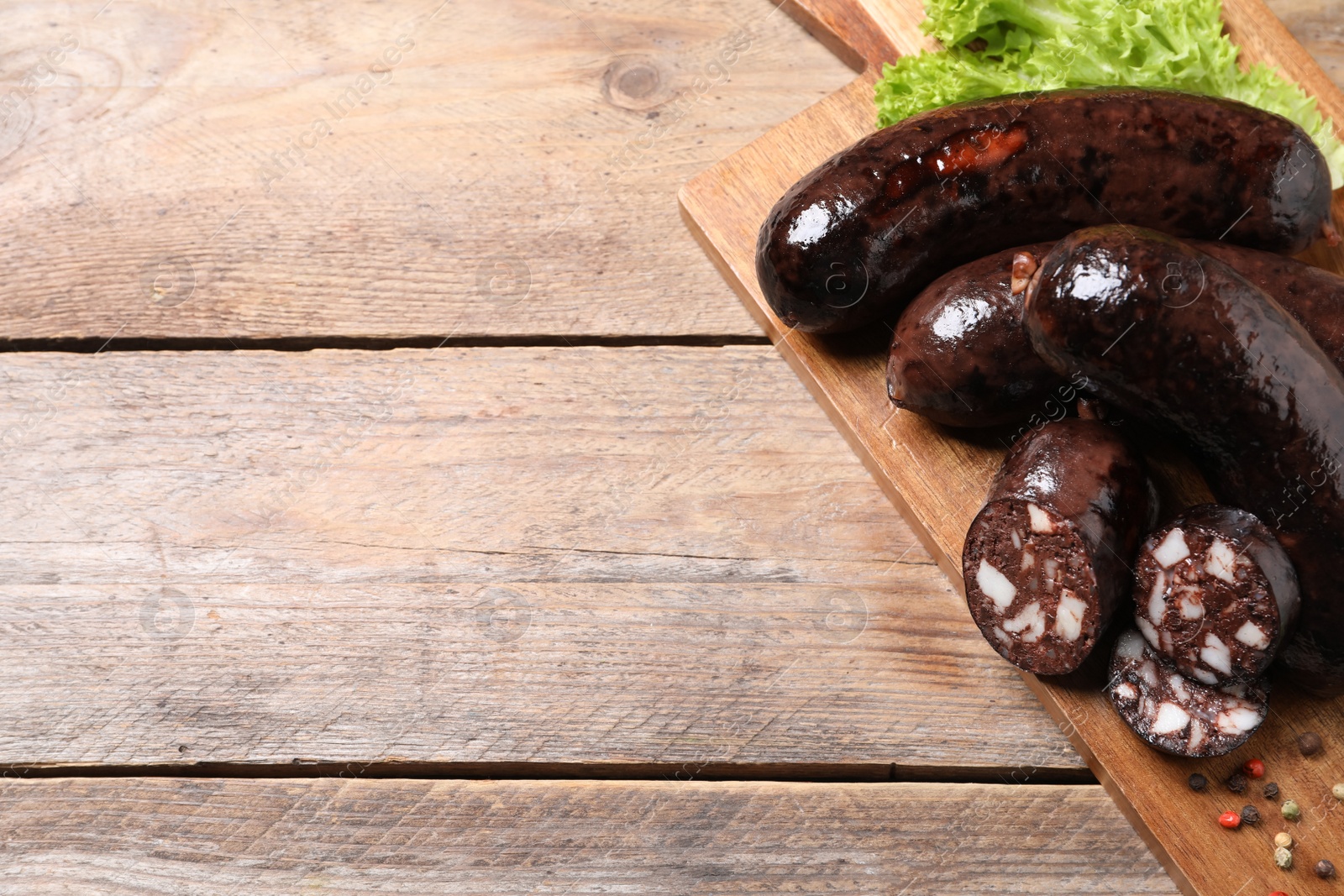 Photo of Tasty blood sausages served on wooden table, above view. Space for text