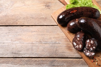 Photo of Tasty blood sausages served on wooden table, above view. Space for text