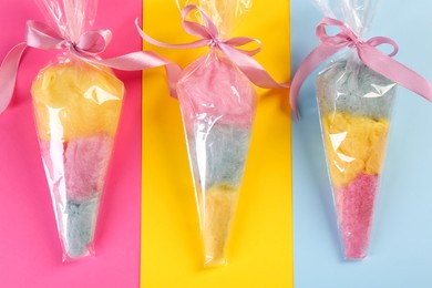 Photo of Packaged sweet cotton candies on color background, flat lay
