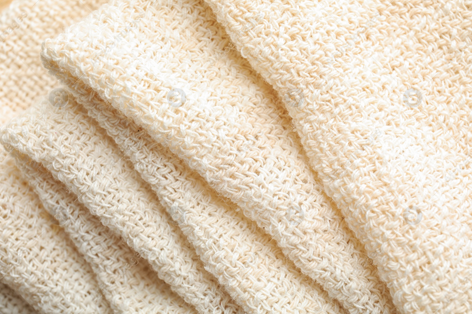 Photo of Closeup view of folded natural hemp cloth. Fabric texture