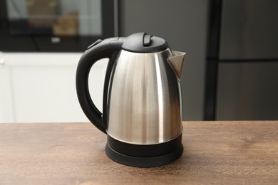 Photo of Modern electric kettle on table in kitchen