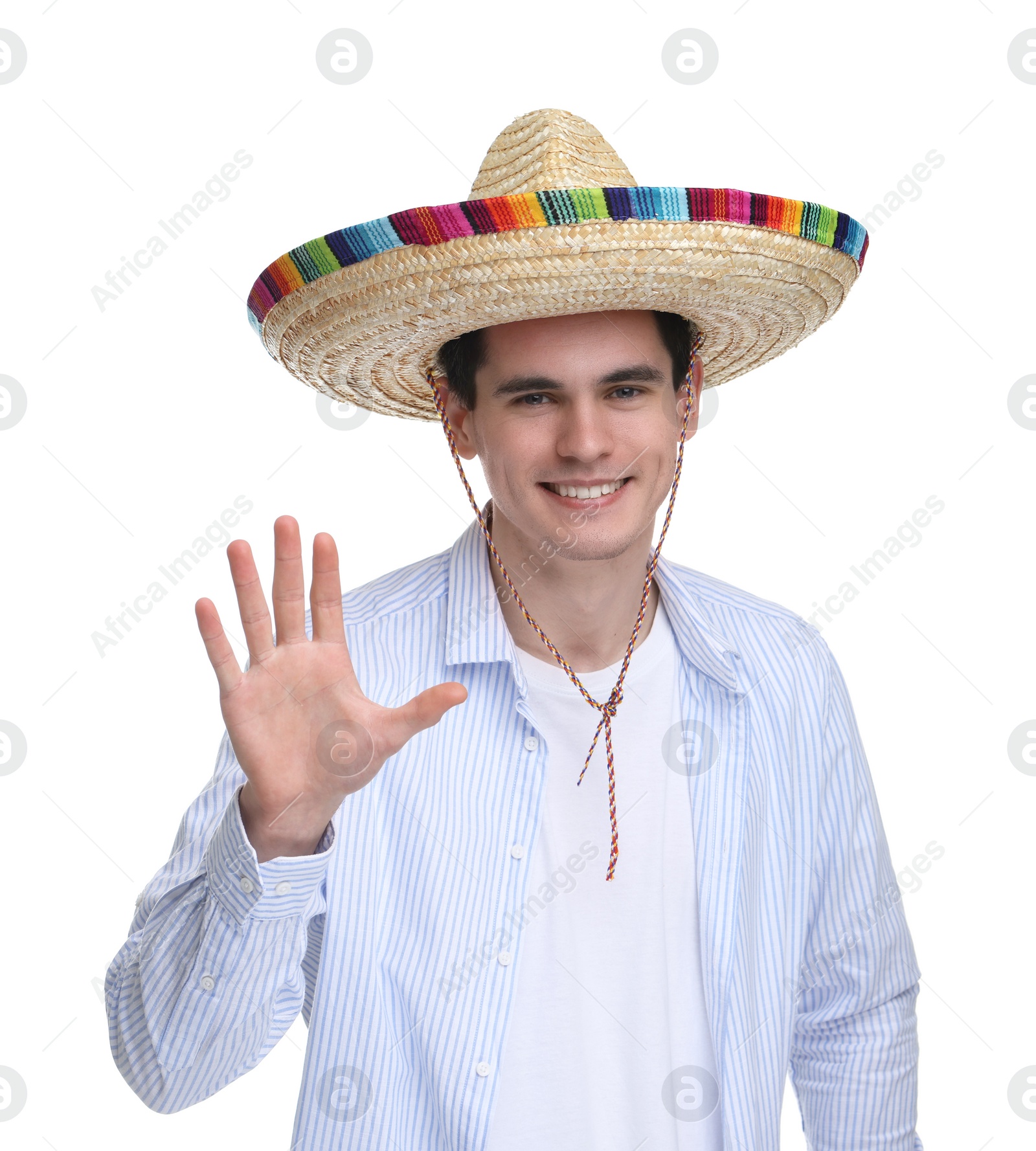 Photo of Young man in Mexican sombrero hat waving hello on white background