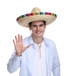 Young man in Mexican sombrero hat waving hello on white background