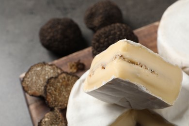Delicious fresh truffle cheese on grey table, closeup. Space for text