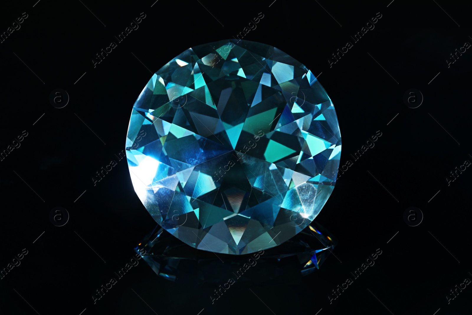 Photo of Beautiful dazzling diamond on black mirror background, closeup