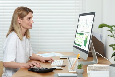 Professional accountant working at wooden desk in office