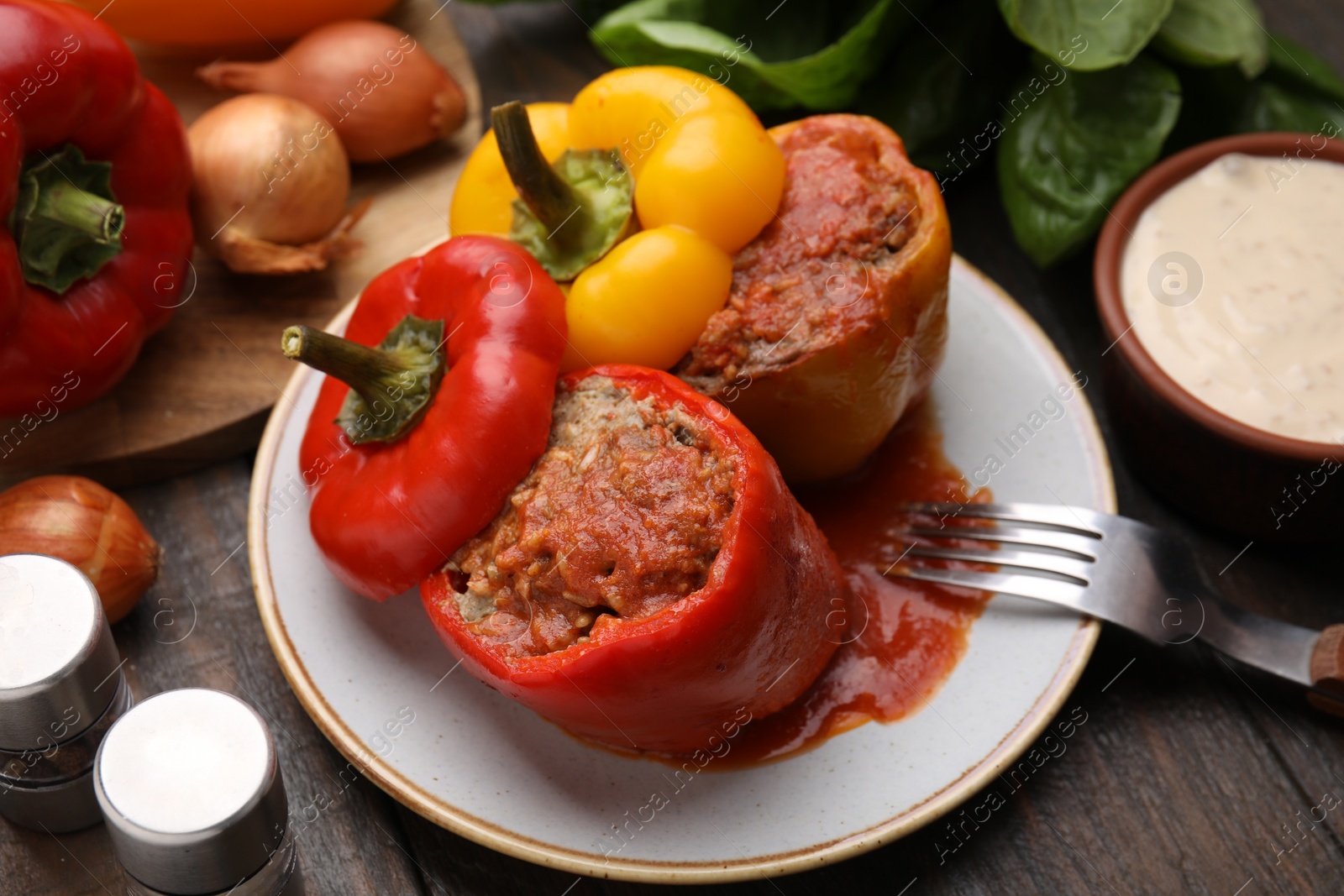 Photo of Delicious stuffed bell peppers served on wooden table