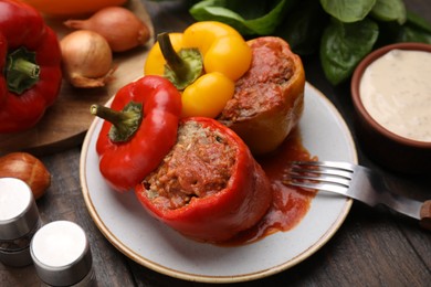 Photo of Delicious stuffed bell peppers served on wooden table