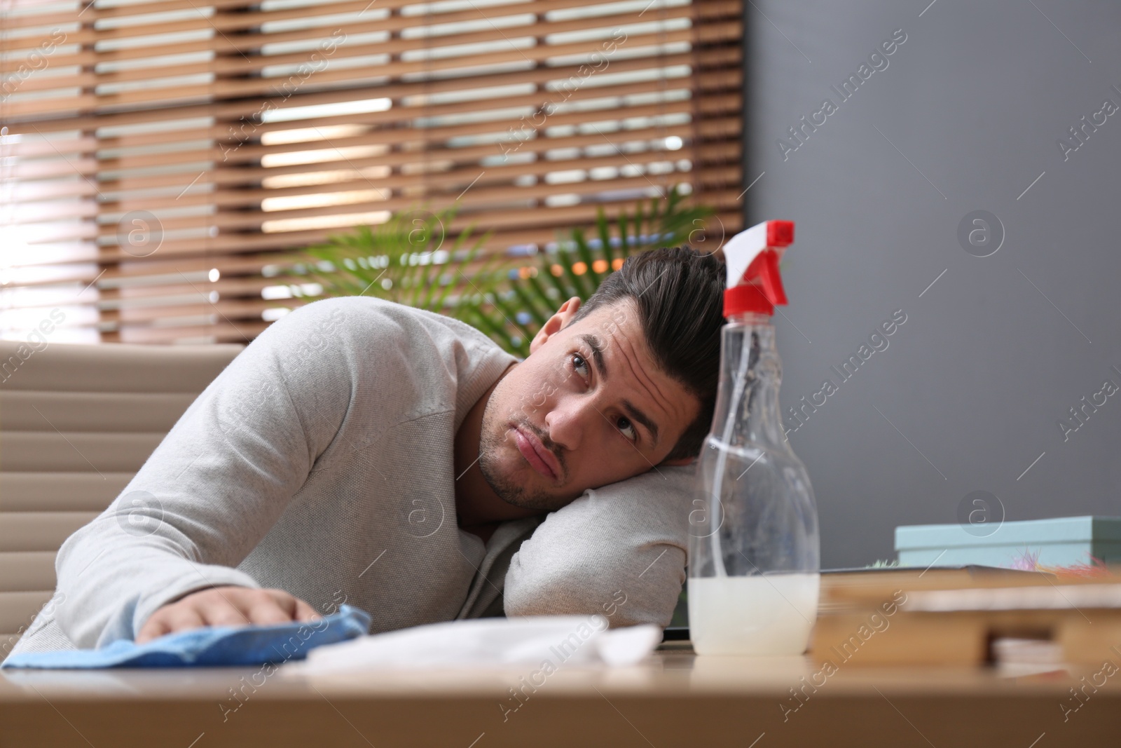 Photo of Lazy man procrastinating while cleaning at home