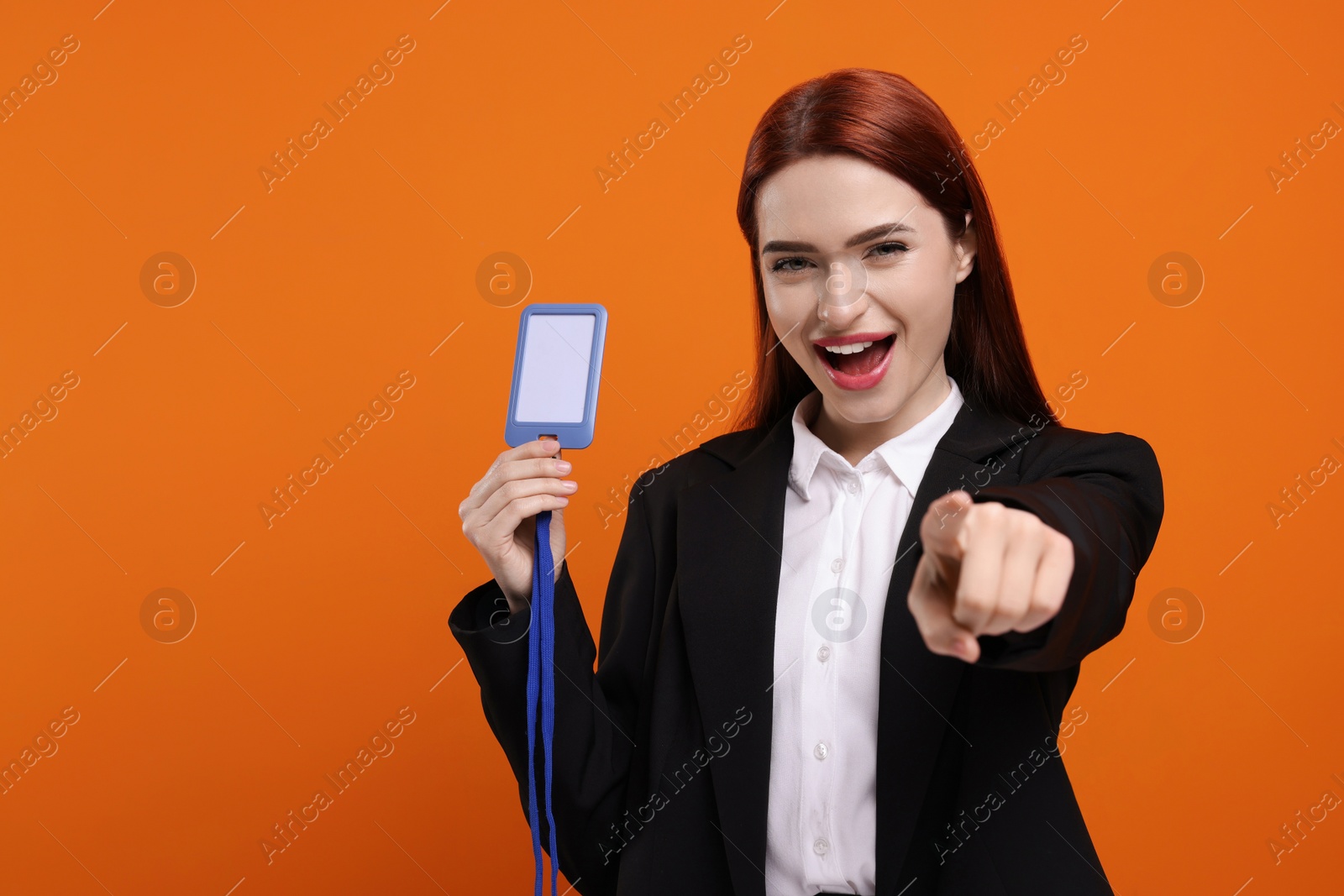 Photo of Happy woman with vip pass badge on orange background, space for text