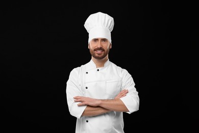 Photo of Smiling mature chef on black background, space for text