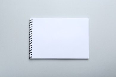 Photo of One notebook on light grey background, top view. Space for text