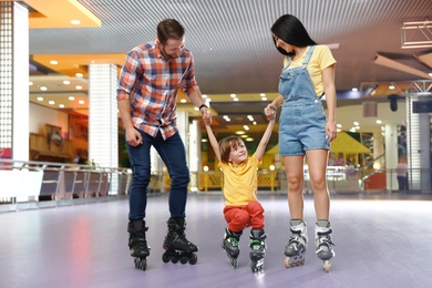 Happy family spending time at roller skating rink