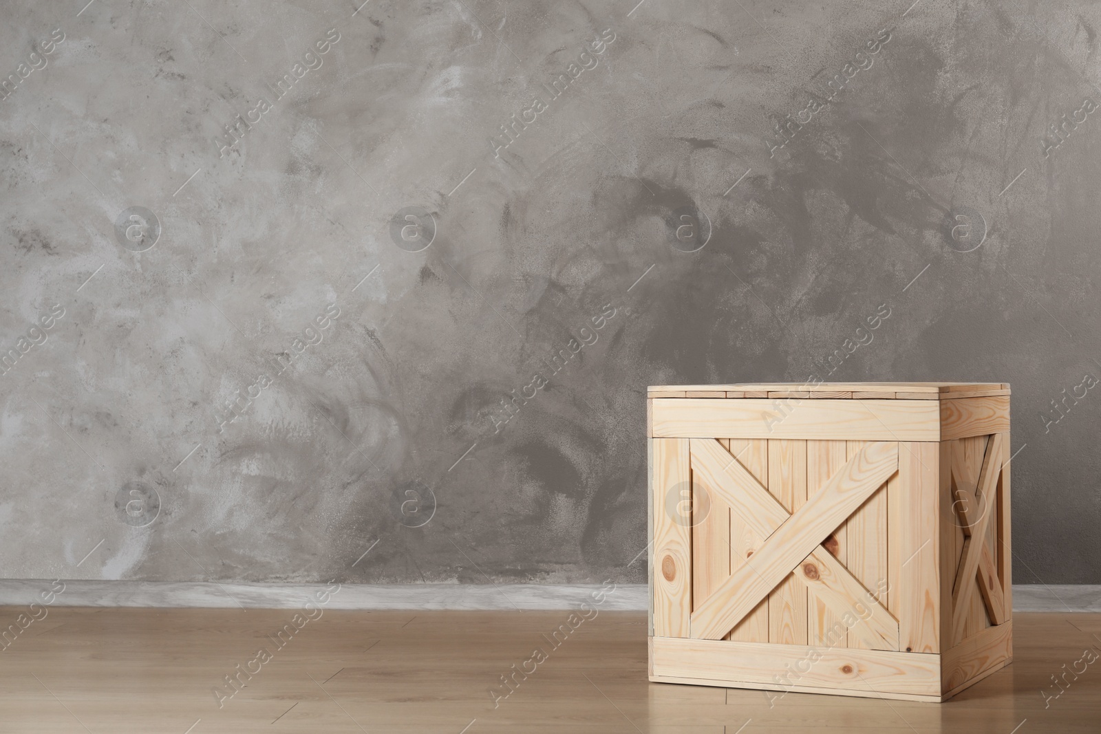 Photo of Wooden crate on floor against color background, space for text