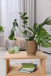 Photo of Ceramic vase with tropical leaves on wooden table in living room