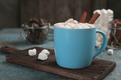 Photo of Cup of chocolate milk with marshmallows on wooden table