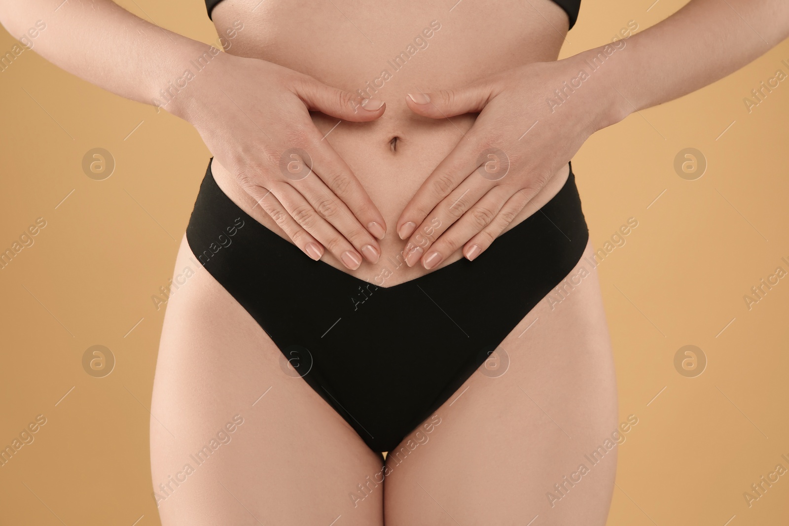 Photo of Gynecology. Woman in underwear on yellow background, closeup