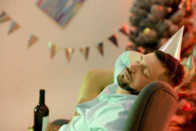 Photo of Drunk man sleeping in messy room after New Year party