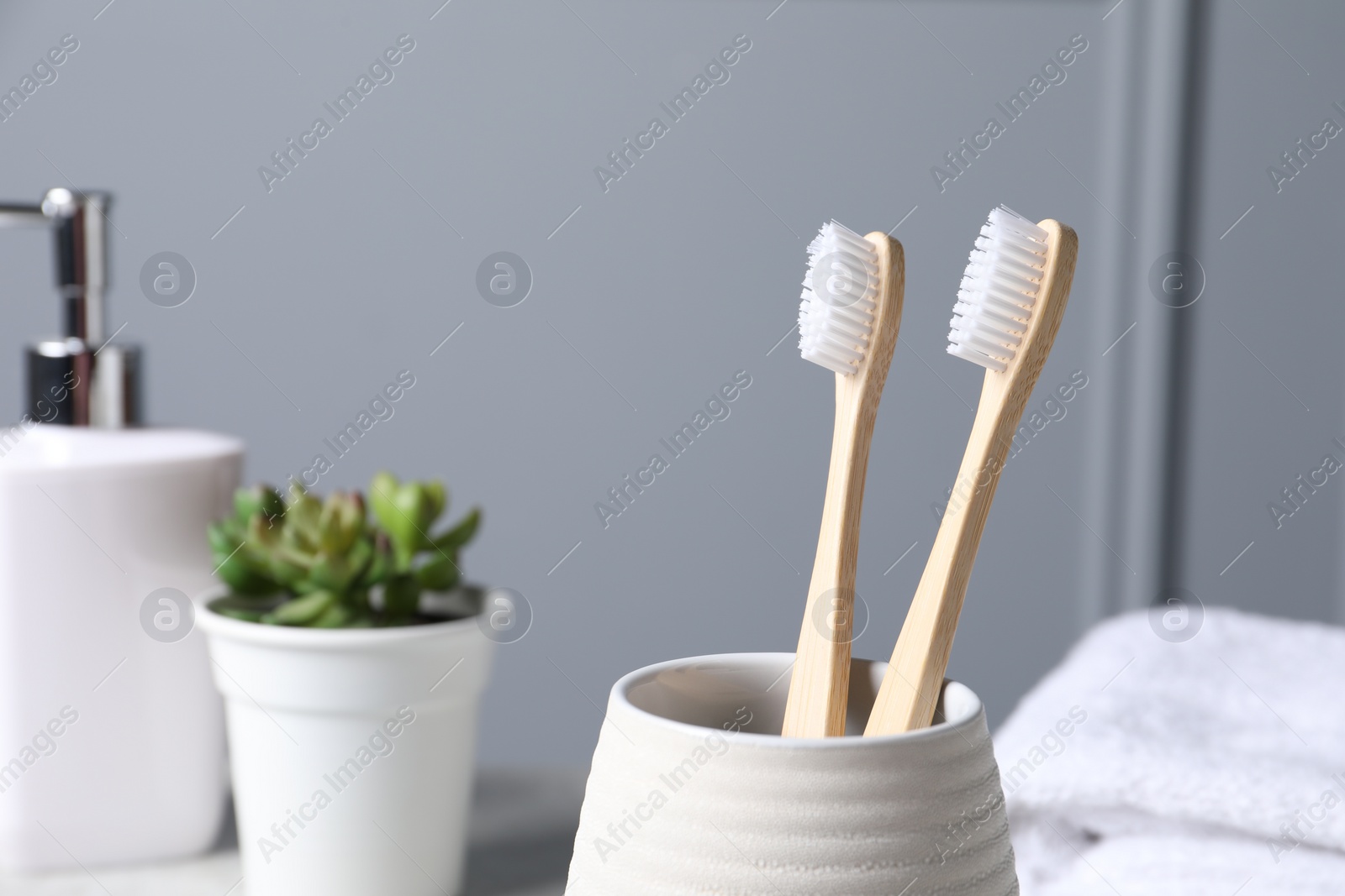 Photo of Bamboo toothbrushes in holder on blurred background, closeup
