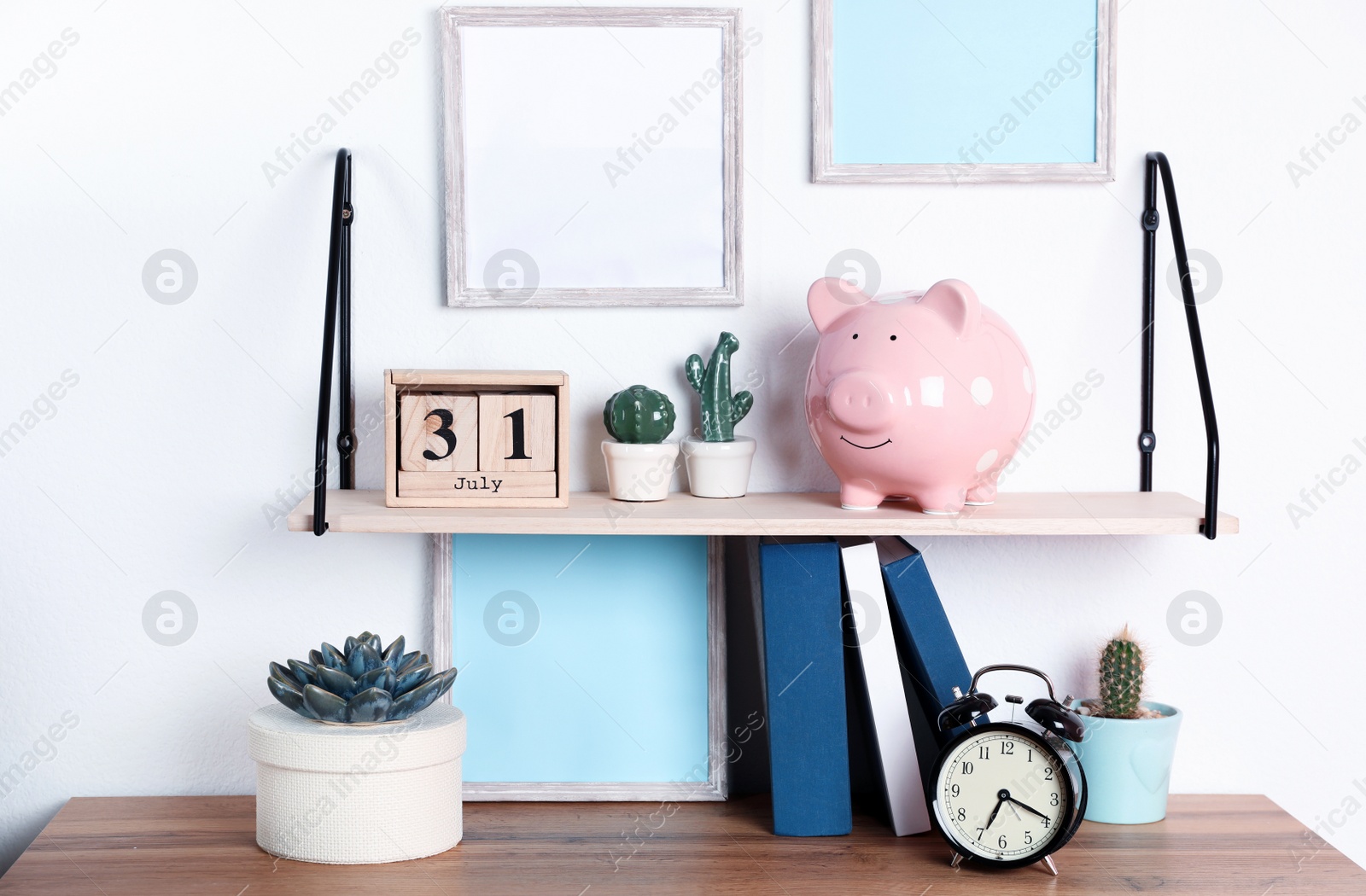 Photo of Color piggy bank on shelf over table in room. Cute interior element