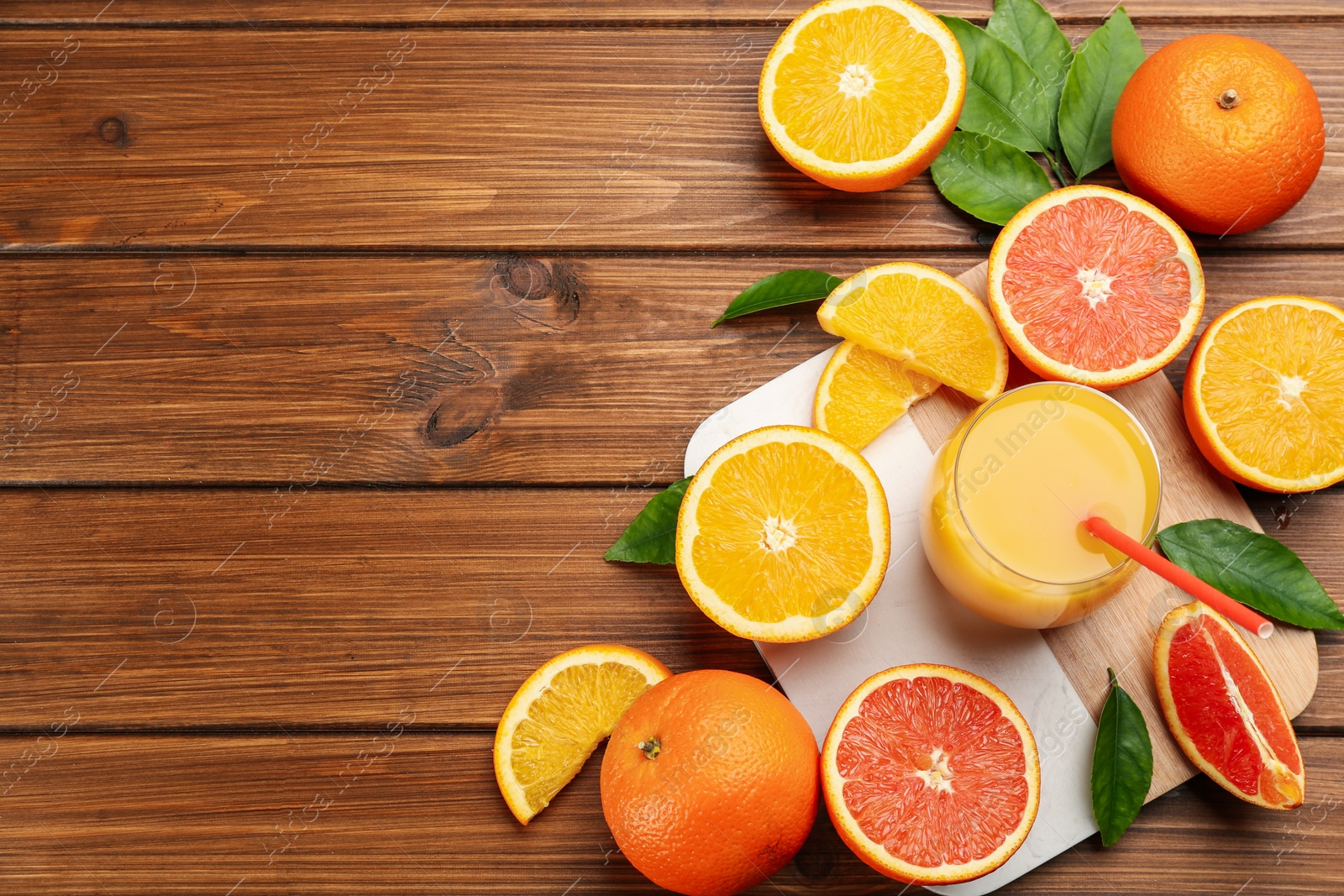 Photo of Delicious orange juice and fresh fruits on wooden table, flat lay. Space for text