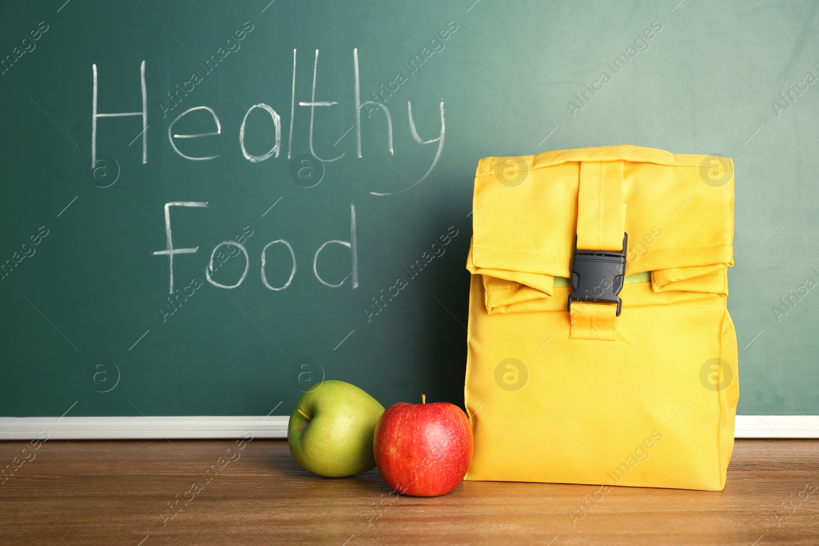 Photo of Lunch for school child on table near chalkboard with written Healthy Food