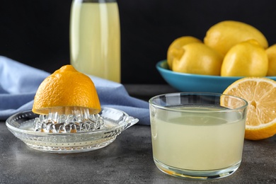 Photo of Composition with glass of freshly squeezed lemon juice on table