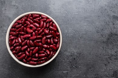 Raw red kidney beans in bowl on grey table, top view. Space for text