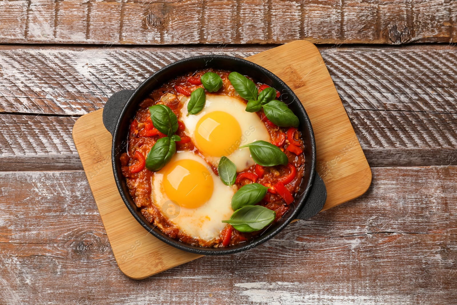 Photo of Delicious Shakshuka on wooden table, top view