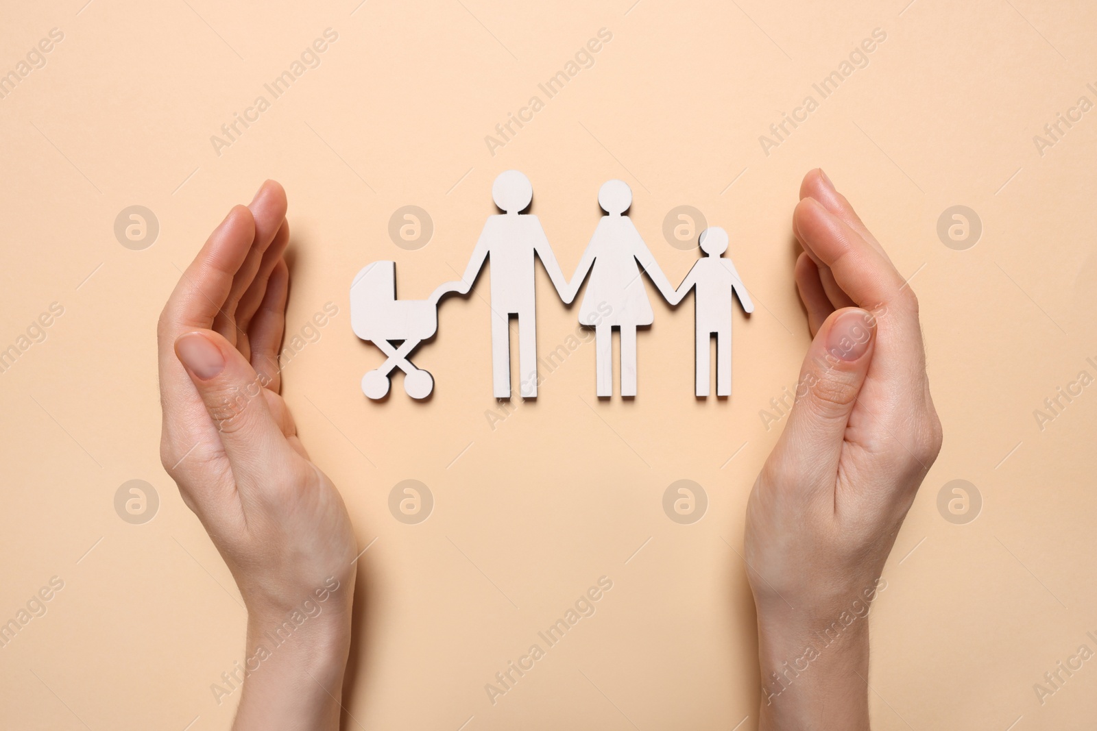 Photo of Woman protecting figures of family on beige background, top view. Insurance concept