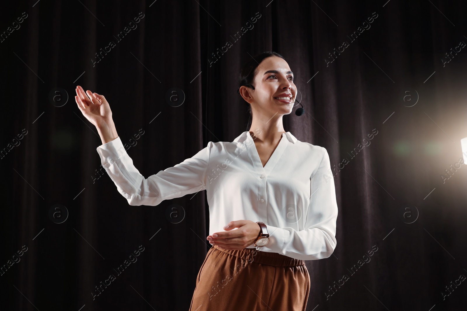 Photo of Motivational speaker with headset performing on stage