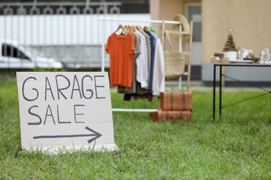 Photo of Sign Garage sale written on cardboard in yard