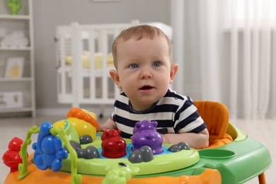 Photo of Portrait of cute baby with toy walker at home. Learning to walk