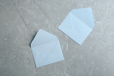 Photo of White paper envelopes on grey marble background, flat lay