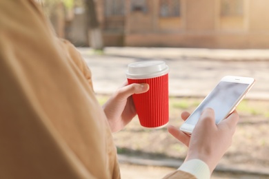 Photo of Young woman using phone outdoors on sunny day