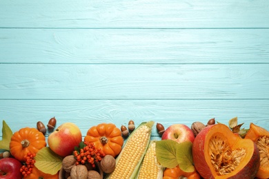 Photo of Flat lay composition with vegetables, nuts and autumn leaves on light blue wooden table, space for text. Thanksgiving Day