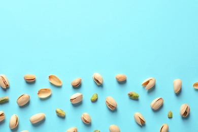 Composition with organic pistachio nuts on color background, flat lay. Space for text