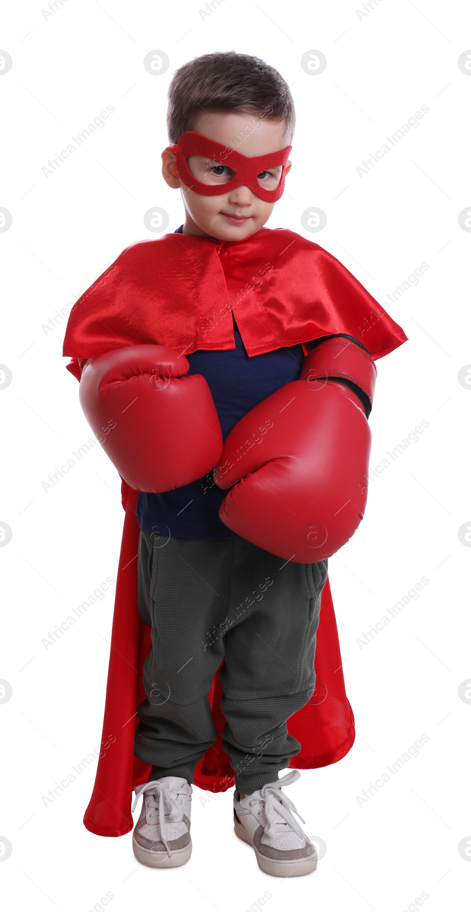 Photo of Cute little boy in superhero suit and boxing gloves on white background