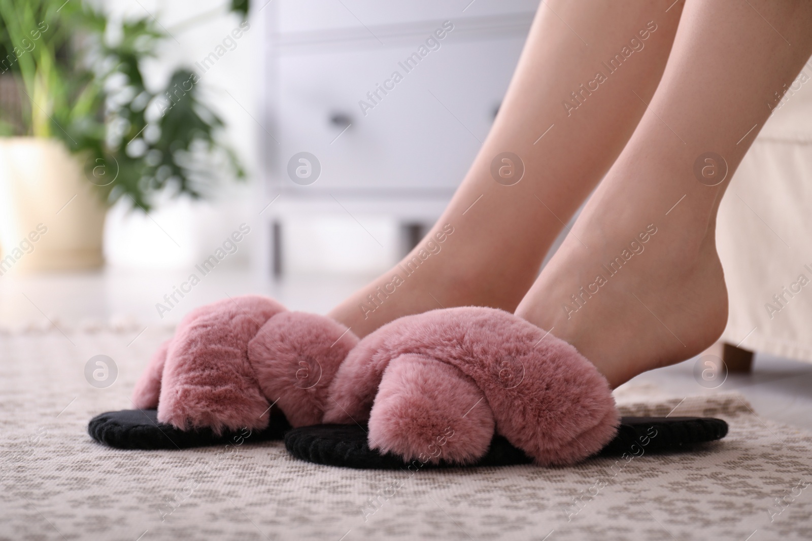 Photo of Woman in fuzzy slippers at home, closeup