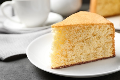 Photo of Piece of delicious fresh homemade cake on grey marble table